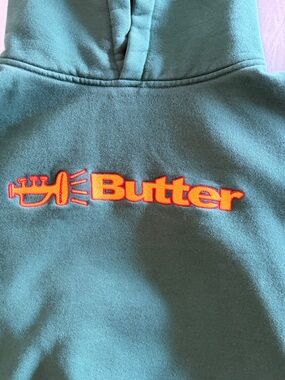 Butter Olive Green Hoodie with Pink Label and Navy Logo